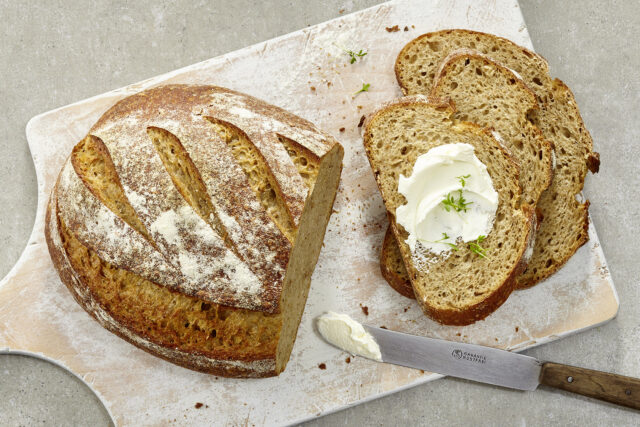 Aufgeschnittenes Brot, eine Scheibe mit Butter bestrichen