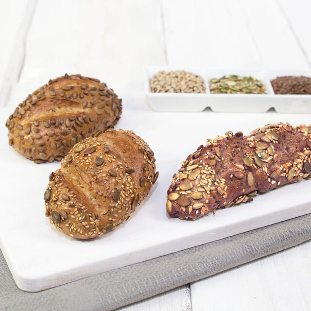 Drei Brötchen mit unterschiedlichen Saaten auf der Oberfläche