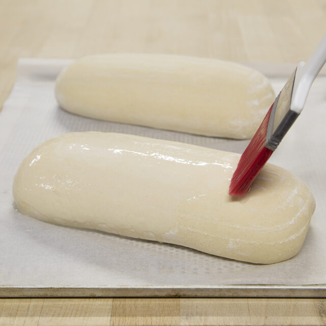 Teig wird mit Pinsel mit GECKO Ultra Saaten- und Dekorkleber eingerieben