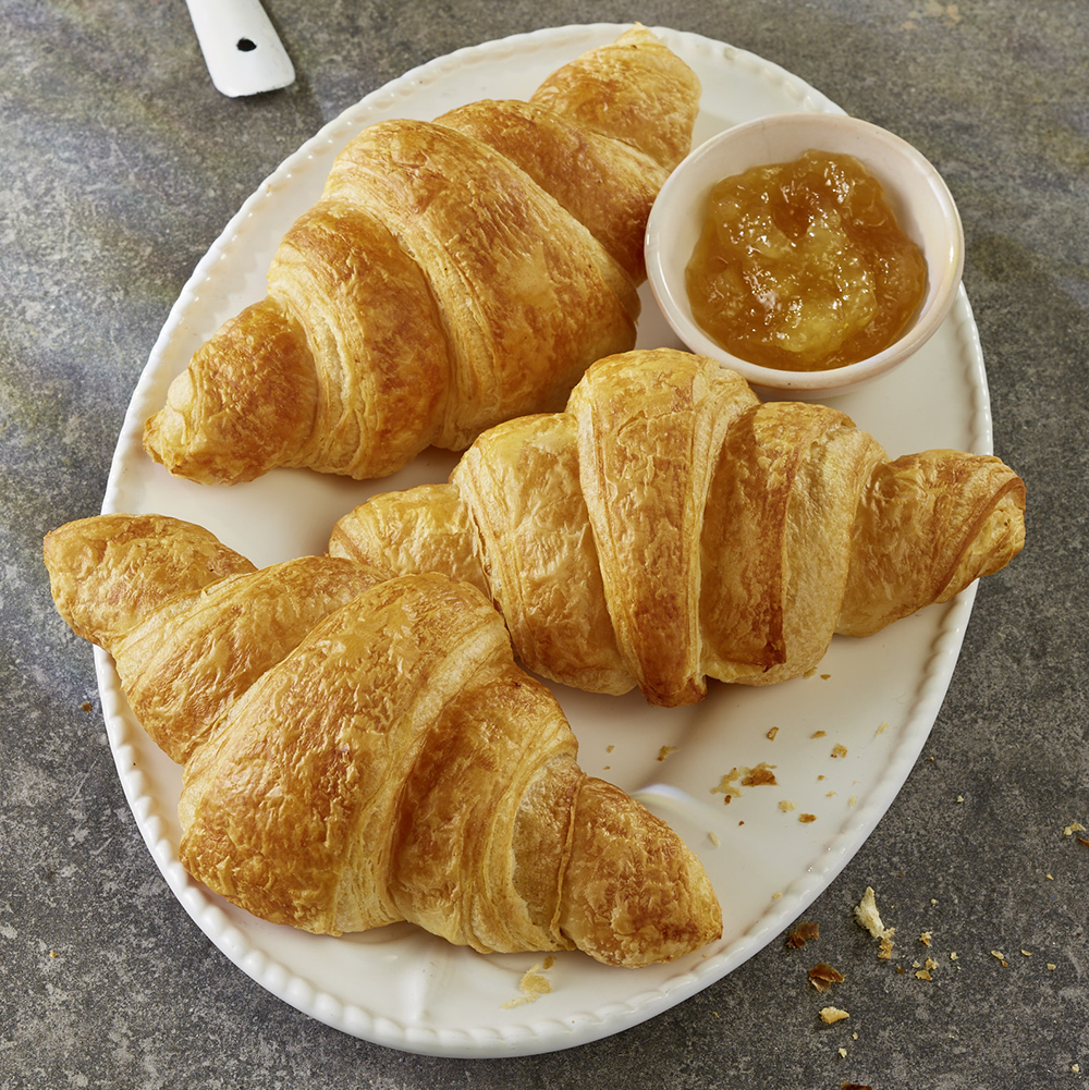 Drei Croissants mit Schälchen mit Marmelade