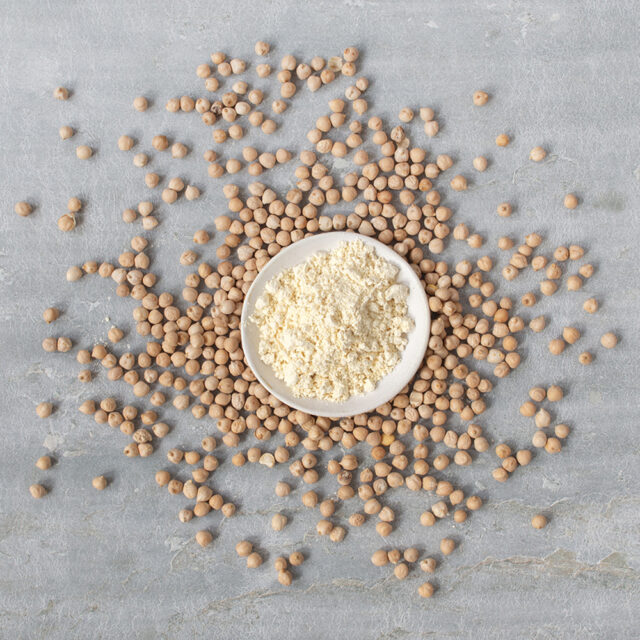 Schale mit Kichererbsenmehl, drumherum Kichererbsen