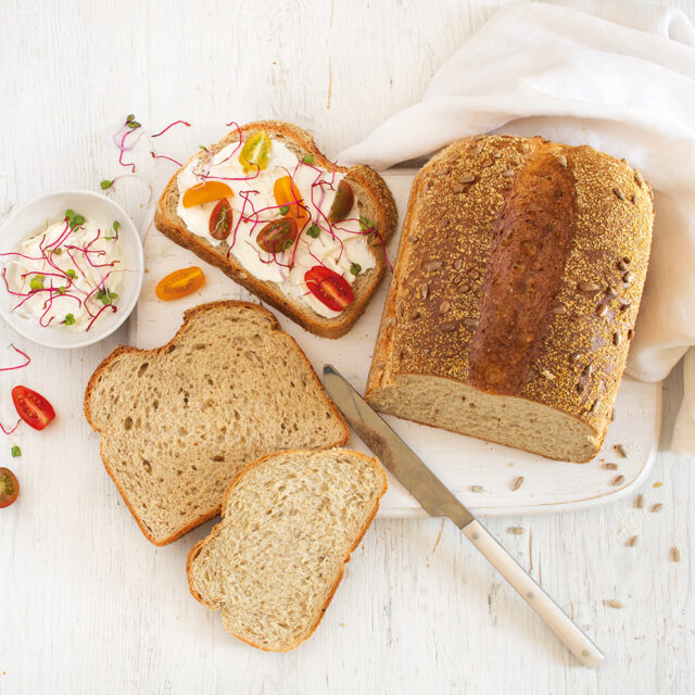 Aufgeschnittenes Gowelltastyprotein Softbrot, eine Scheibe belegt mit Tomaten und Frischkäse