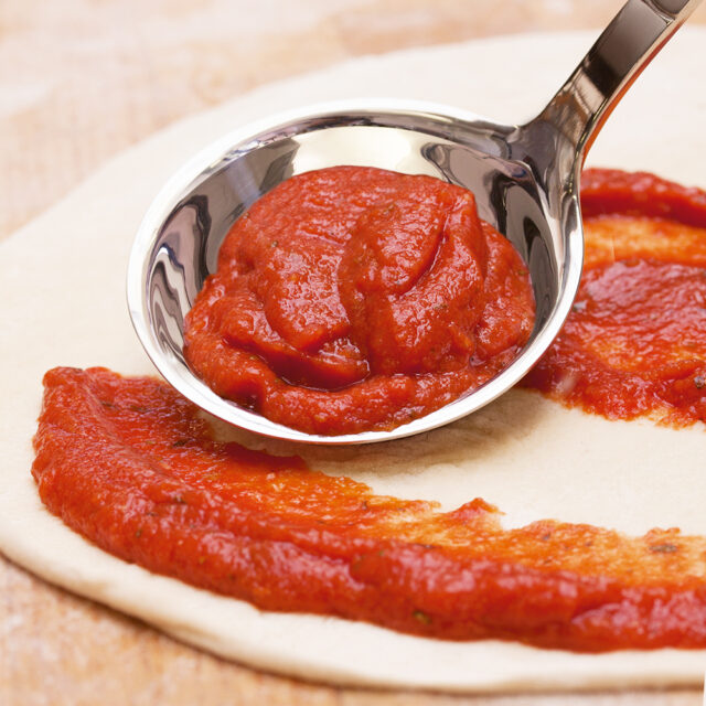 Phoenix Basis Pizza Topping wird auf Pizzaboden verteilt