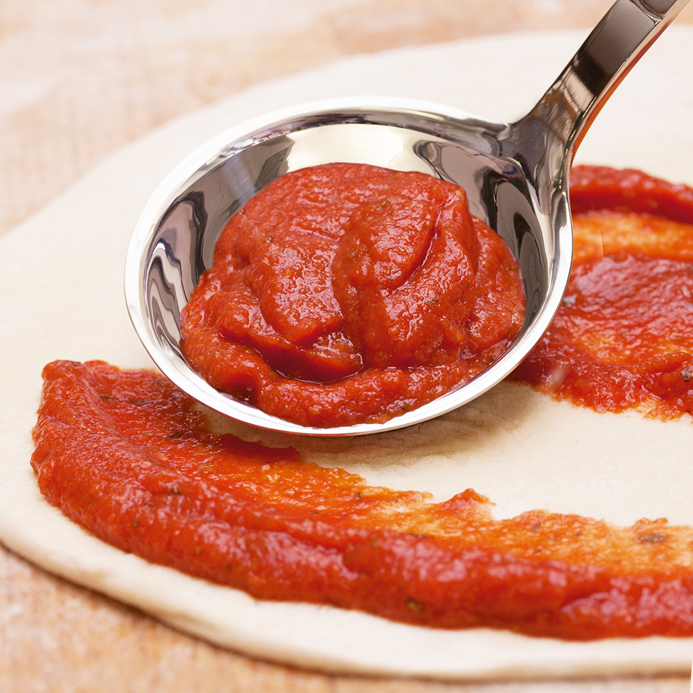 Phoenix Basis Pizza Topping wird auf Pizzaboden verteilt