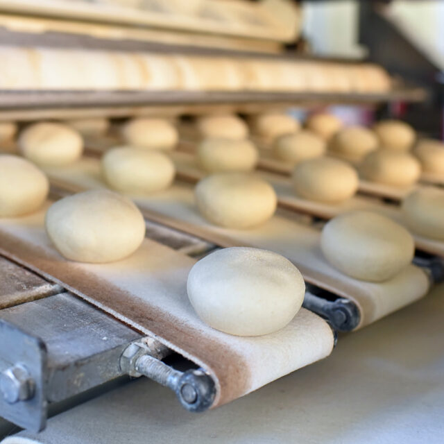 Fliessband mit Brötchen in einer Fabrik - automatisierte Produktion