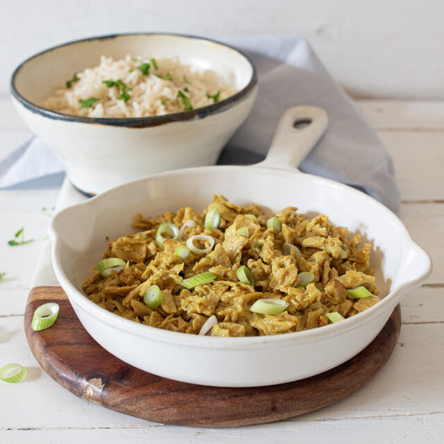 Vitatex Geschnetzeltes, zubereitet mit Frühlingszwiebeln, gekochter Reis im Hintergrund